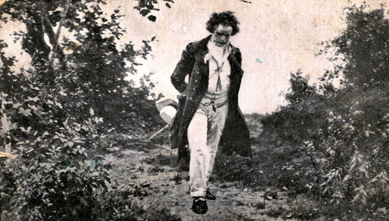 A nineteenth-century painting of Beethoven walking alone through wooded countryside, hat in hand