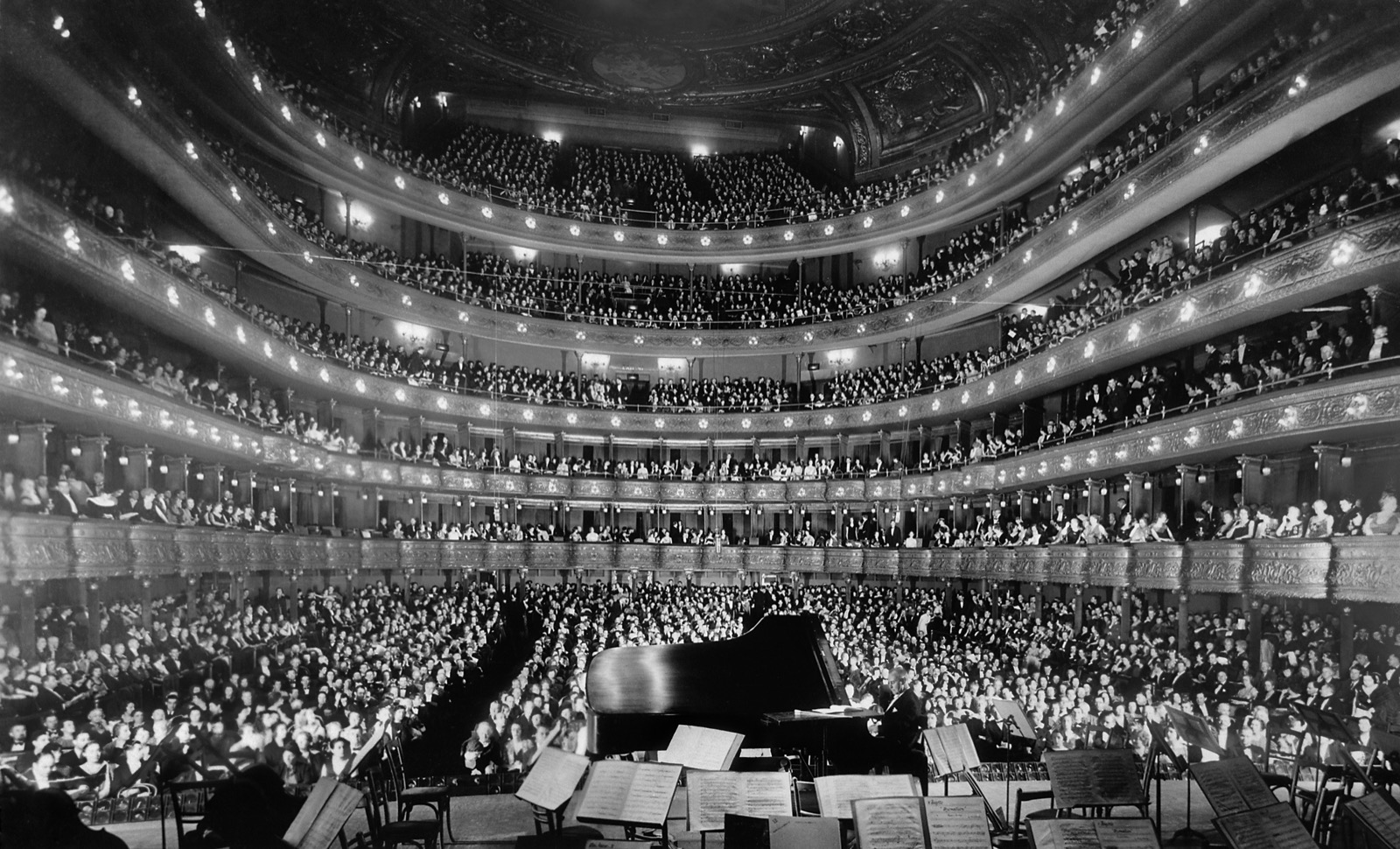 A full concert audience seated in the tiered Metropolitan Opera House