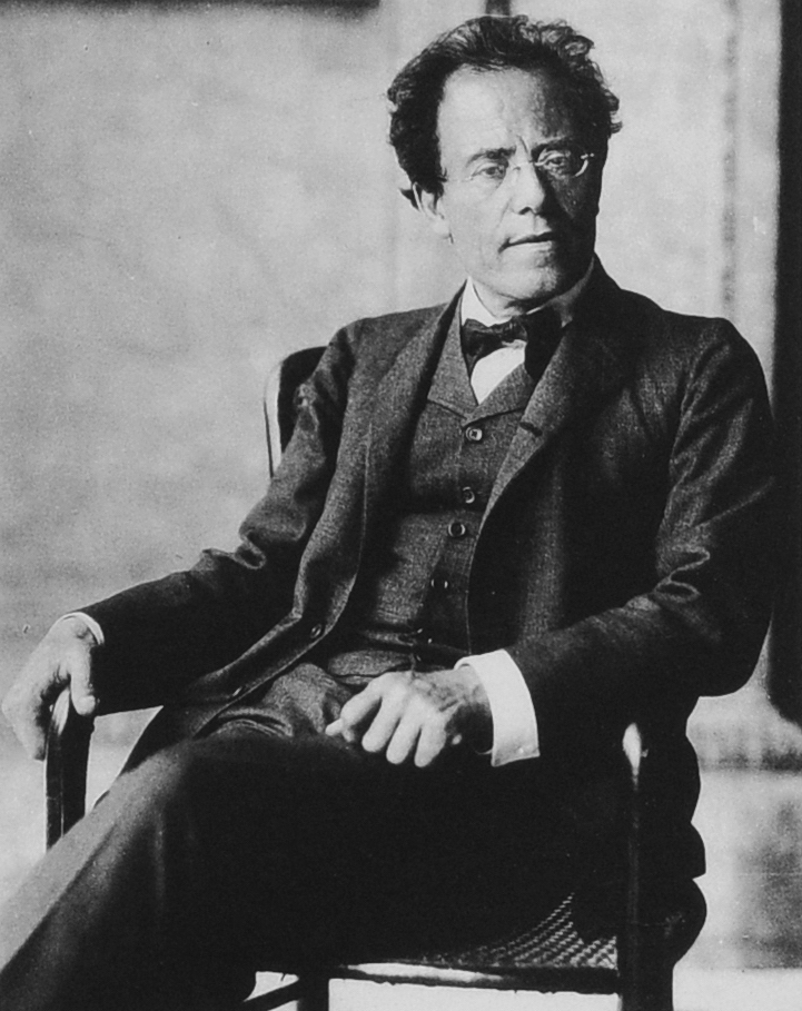 Portrait photograph of composer Gustav Mahler, seated and wearing glasses