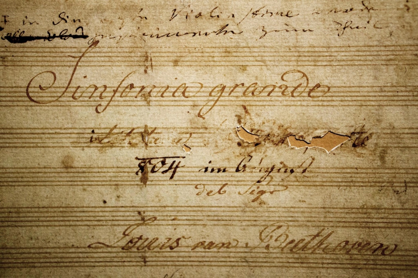 Title page of the copyist manuscript of Beethoven's Third Symphony, headed Sinfonia grande, with the dedication scraped away leaving a hole in the paper