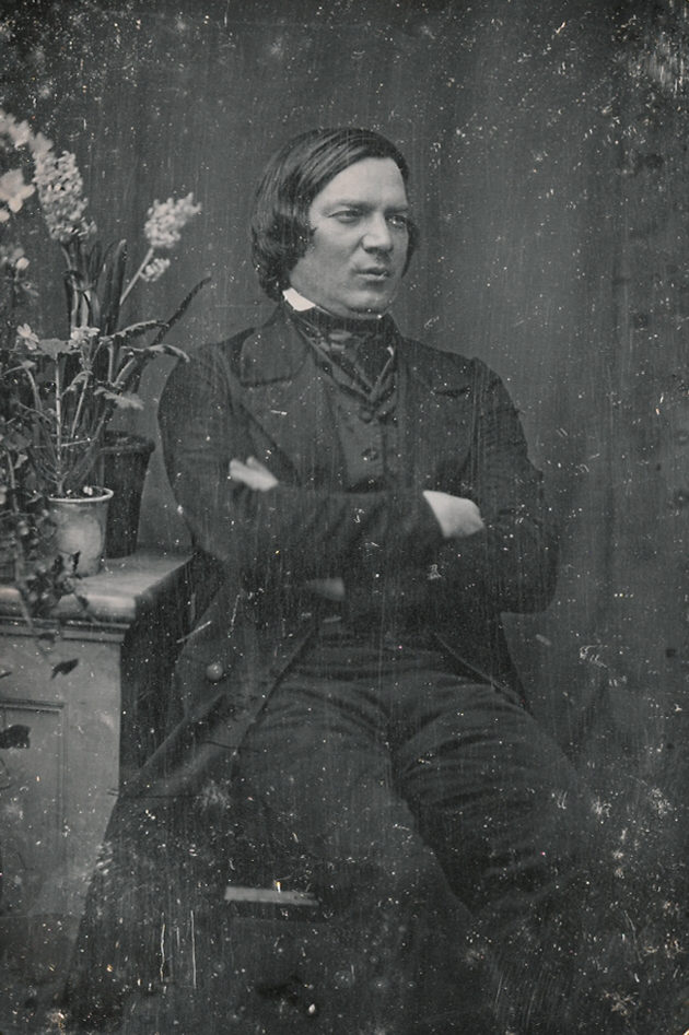 Daguerreotype portrait of composer Robert Schumann in a dark coat with folded arms